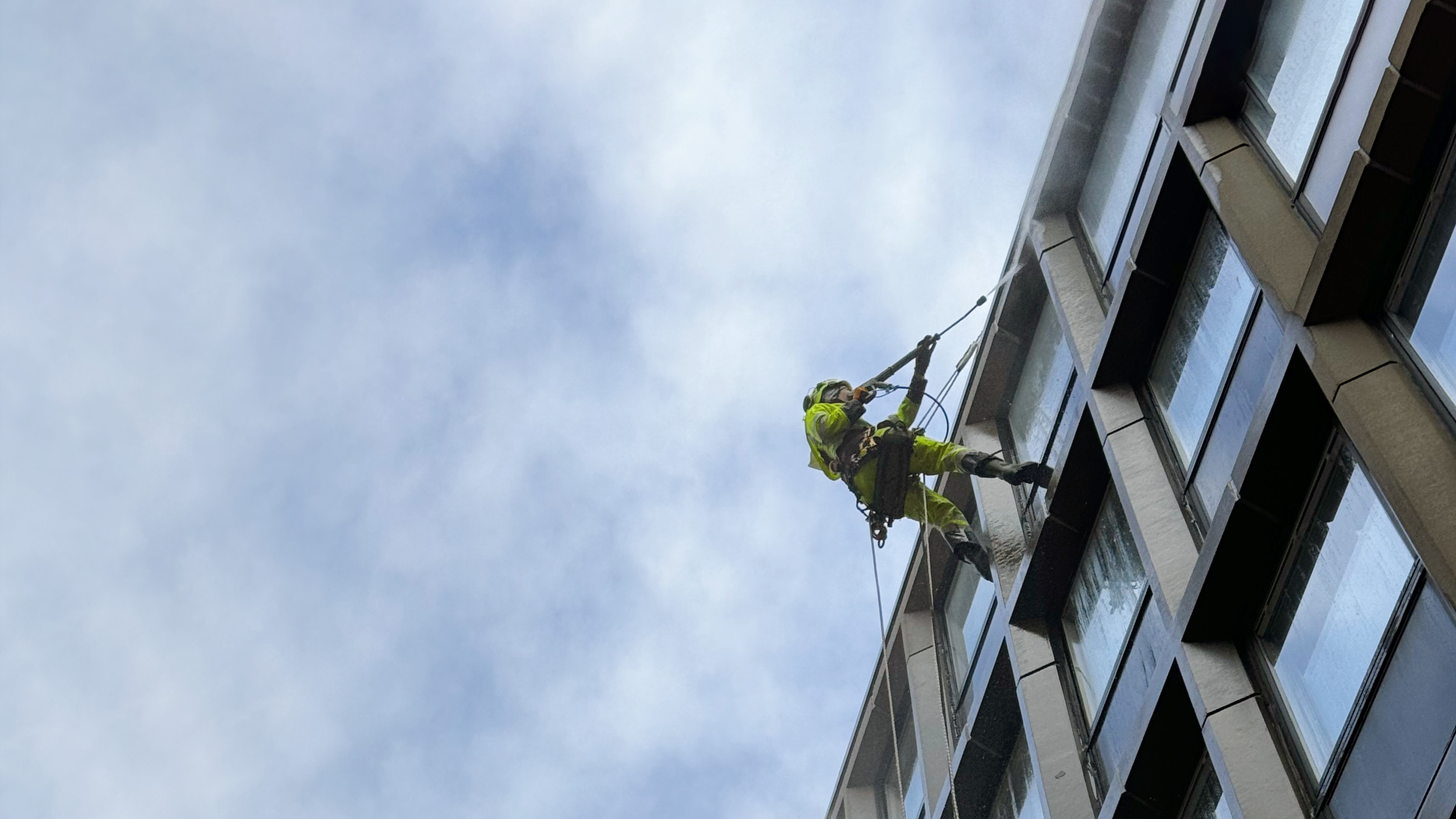 Fasadarbete och fasadtvätt utförs av en person på hög höjd