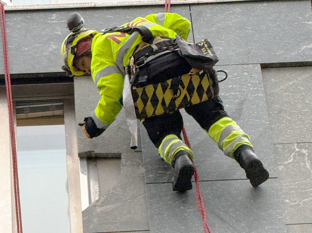 Person utför fasadarbete på hög höjd