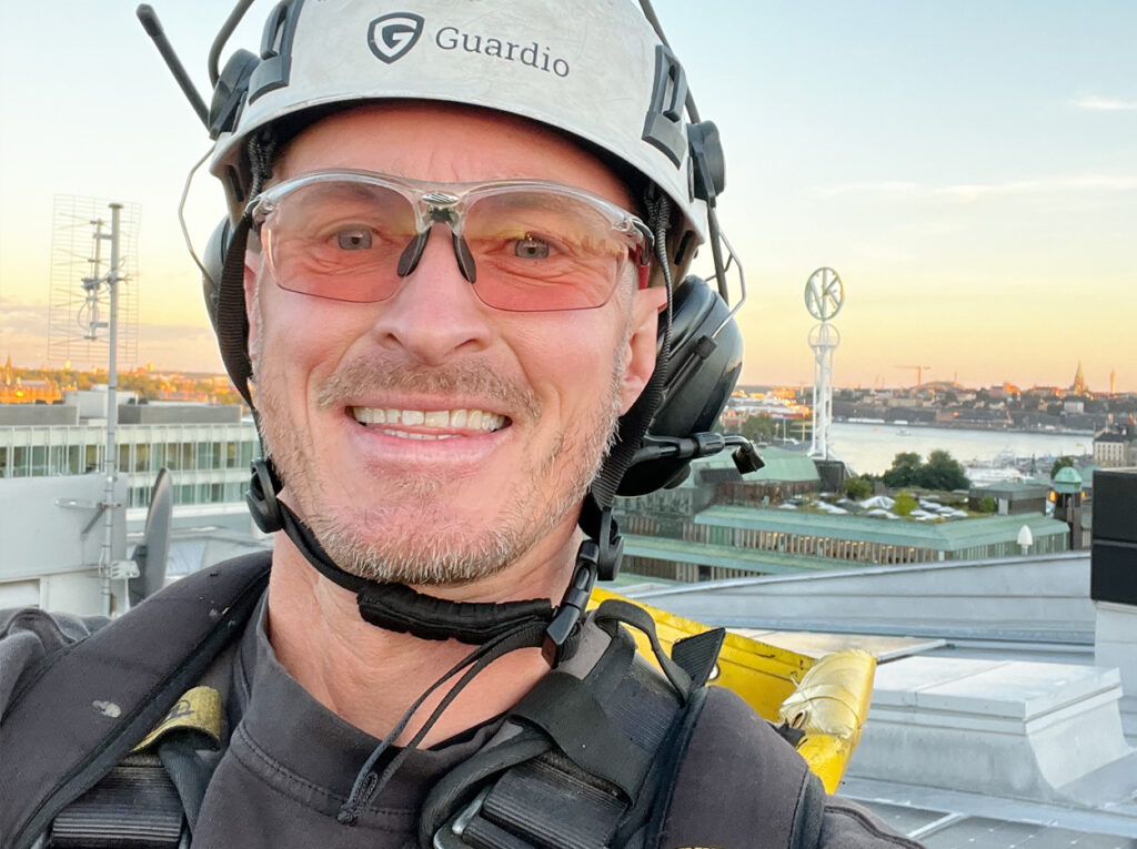 Närbild på höghöjdsarbetare med Stockholm i bakgrunden